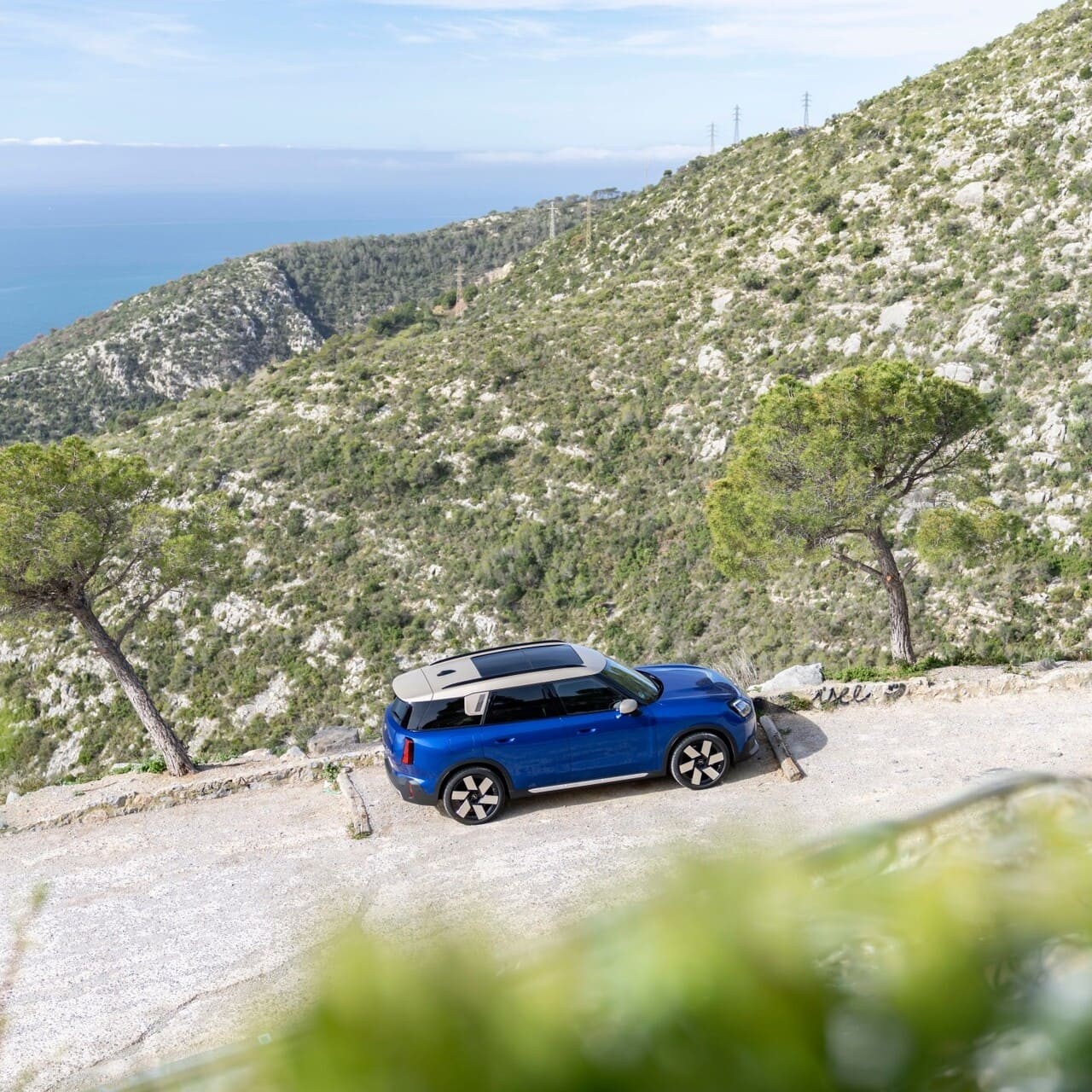 MINI Countryman E estacionado no meio de paisagem natural.